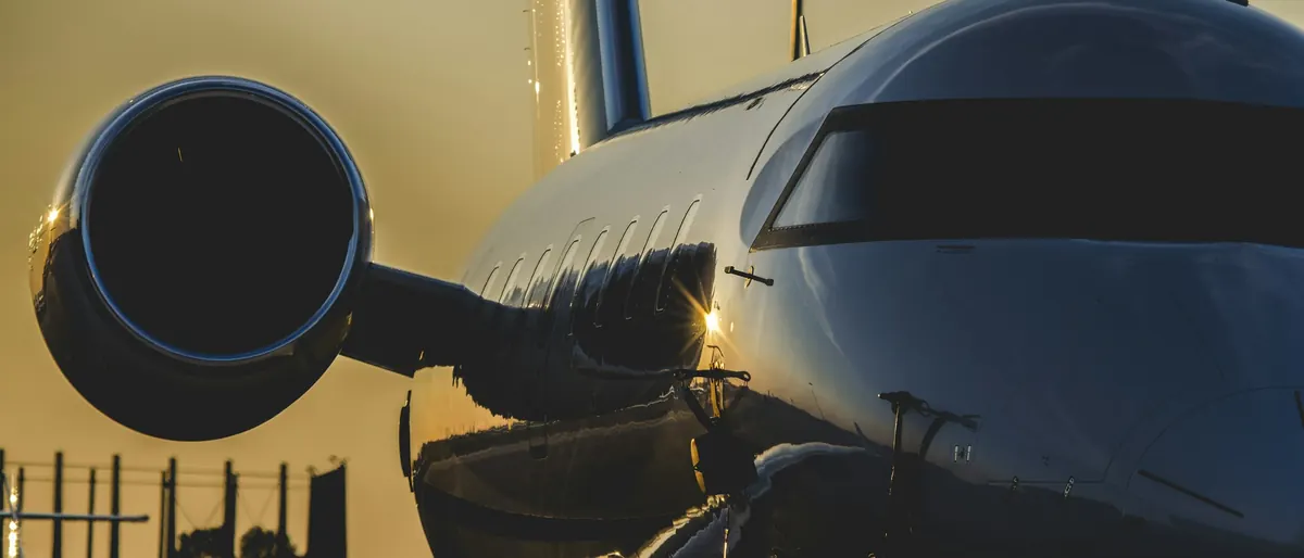 Close view of a business jet engine and cockpit catching golden evening light