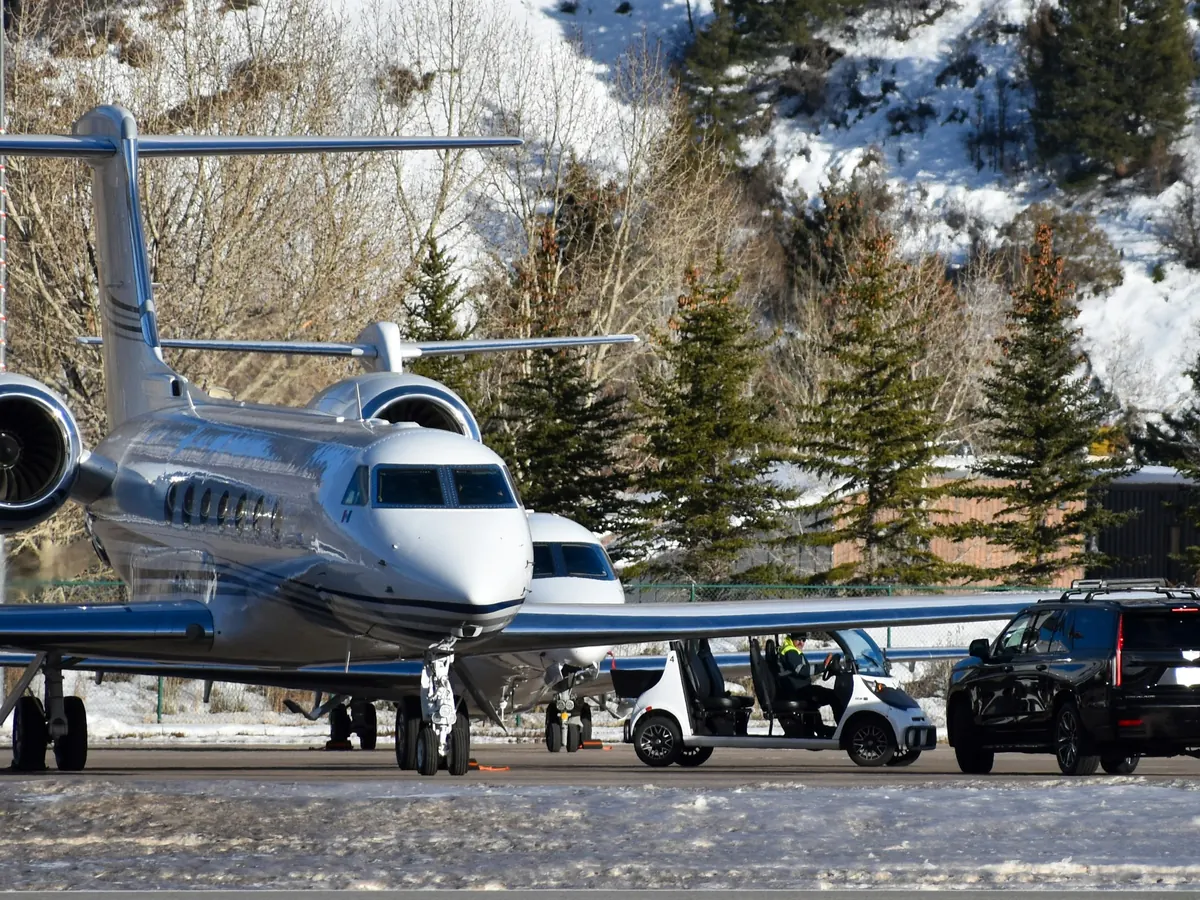 Business jets parked on a snowy mountain airport ramp