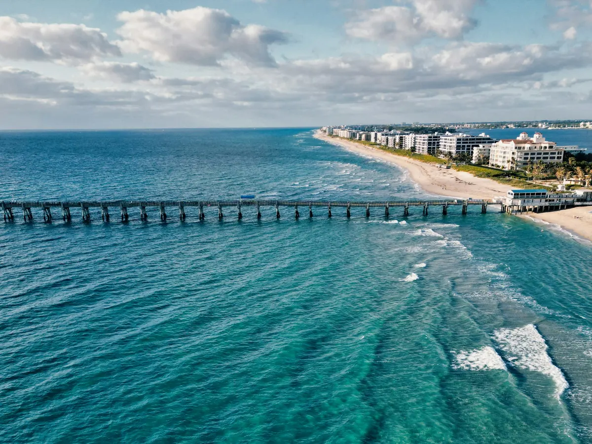 Aerial view of a long pier and beach on Florida's Atlantic coast